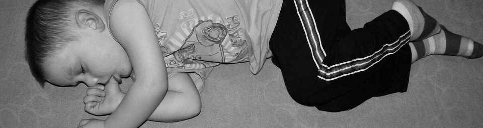 child sleeping on floor sucking thumb