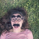 girl with groucho glasses in grass